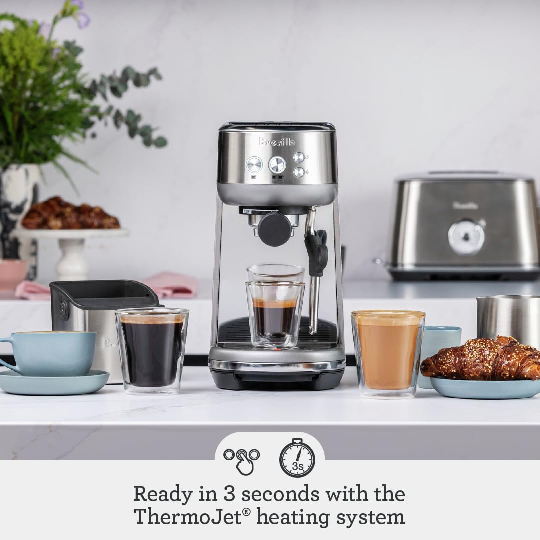 Breville Bambino accessories included in the box: stainless steel portafilter, milk jug, single and dual wall filter baskets, tamper, descaler, and steam wand cleaning tool