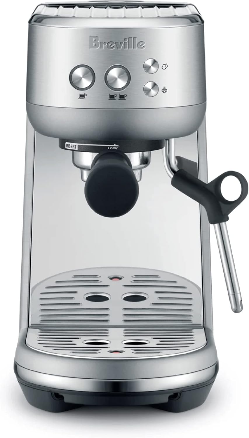 Breville Bambino BES450 espresso machine on a kitchen counter pulling a shot of espresso, with cups and a croissant nearby